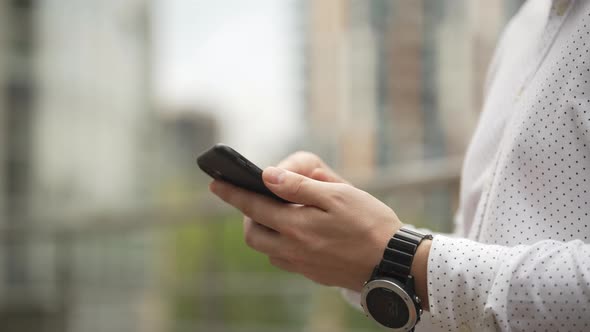 Closeup of a Man Texting on the Phone with Positive Emotions