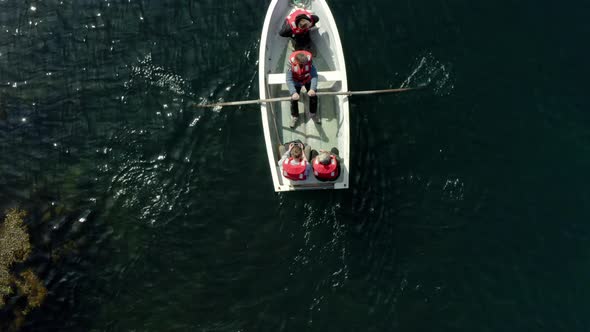 Wooden Boat With People Rowing On Turquoise Water Near Flatey Island, Breidafjordur Bay, Iceland.