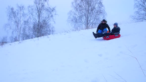 Happy Family Rides and Smiling Snowtube on Snowy Roads