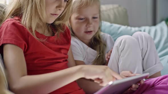 Blond Little Girl Playing on Tablet alt