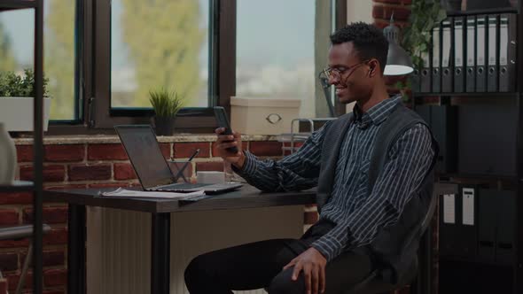 Office Worker Using Smartphone to Talk on Video Call at Job