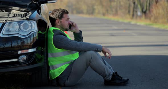Sad Businessman Use Phone Sitting on Road Near the Broken Car Opened the Hood Help Repair Stress