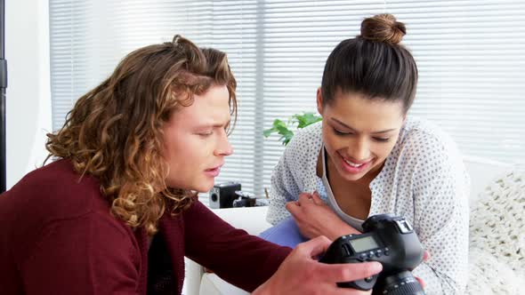 Photographer showing photos to fashion model