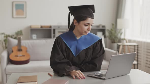 Female Graduate Using Laptop at Home