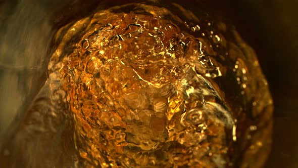 Super Slow Motion Abstract Shot of Pouring Golden Liquid in Glass Bottle at 1000 Fps