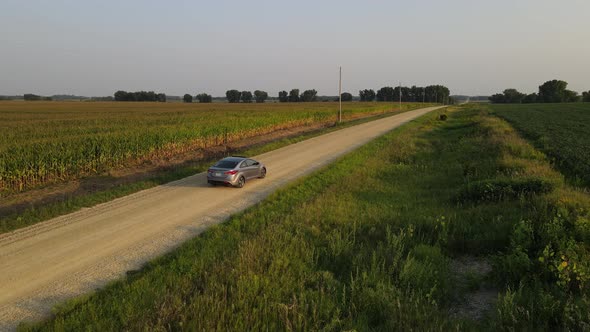 driving a car on dirt roads near farm, fields country side,  during summer time