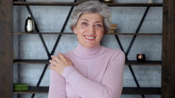 Smiling Mature Gray Haired Middle Aged Woman Looks at the Camera, a Happy Old Lady Poses at Home