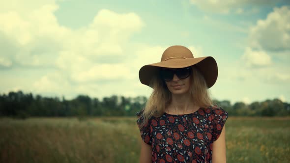 Woman Walking On Summer Field. Girl In Wicker Hat Walking On Meadow. Green Grass Field