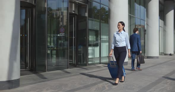 Slider Shot of Asian Businesswoman in Formal Wear Walk Outdoors Carrying Suitcase