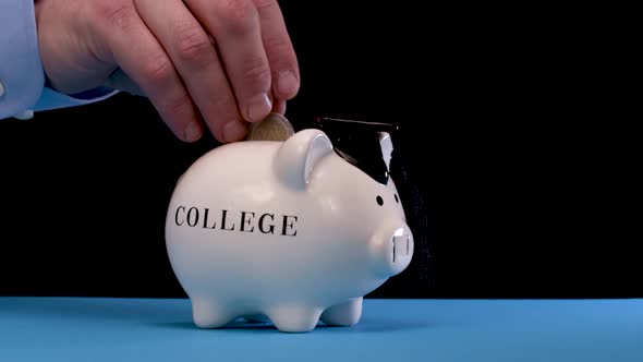 Hand Puts Coins in Piggy Bank.