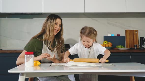 Funny Girl Rolls Dough with Wooden Pin Cooking with Mommy