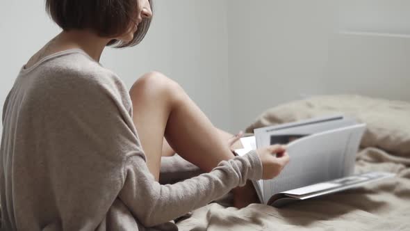 Young Female Student Browses the Magazine for Training at the University