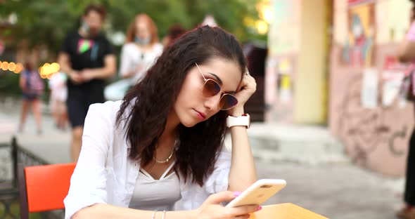 Young Woman with Glasses Uses the Phone.