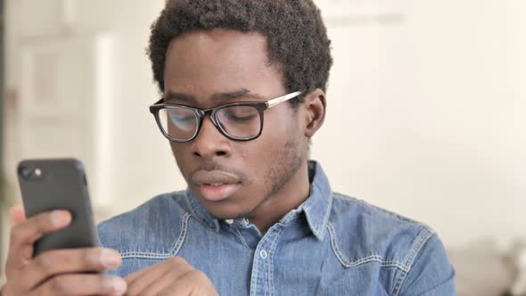 African Man Reacting To Loss While Using Smartphone