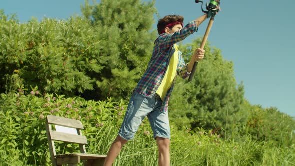 Portrait of Lovely Middle Eastern Boy Casting Spin Fishing Rod on Pond