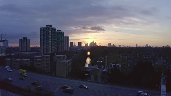 Establishing Aerial drone dolly forward shot of London Canal towards city skyscrapers at sunset