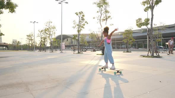 4K Little African girl practicing longboard sakting at the park on summer vacation