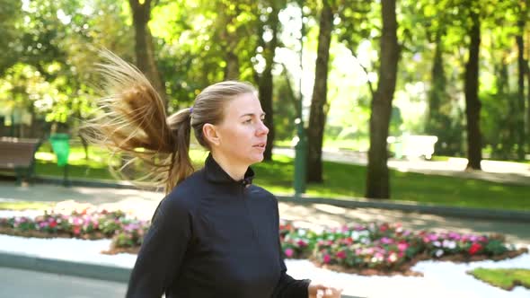 Blonde Woman Jogging in Sunny Park