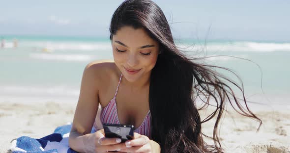 Pretty Girl Using Phone on Beach
