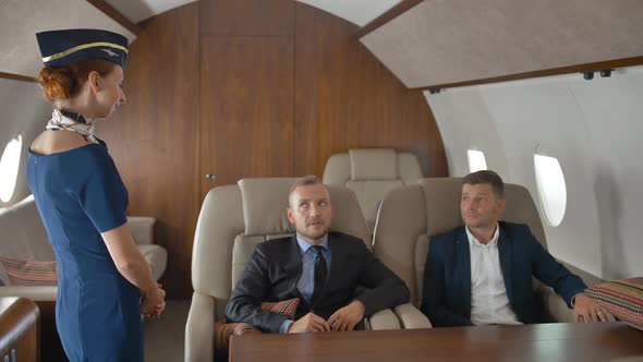 Business People, Inside of Private Jet Relaxing While Flying and Speaking with Stewardess