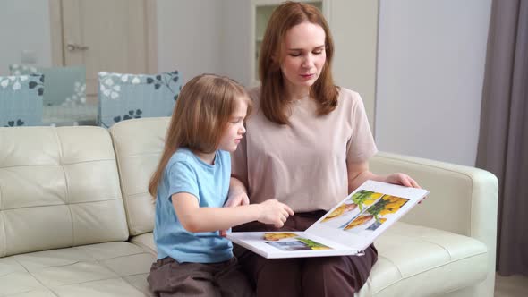 Mother and Daughter Looking a Book with Photos From a Family Photo Shoot