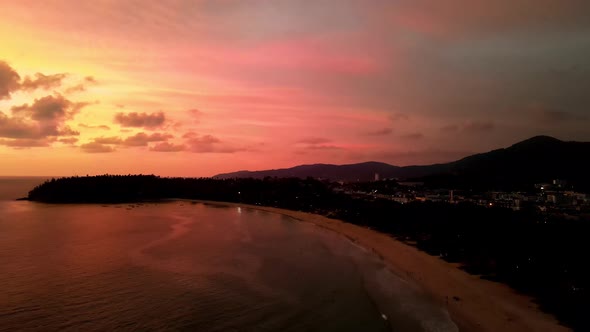 Tropical Orange Sunset Skies Over Silhouette Kata Beach In Phuket. Aerial Dolly Forward