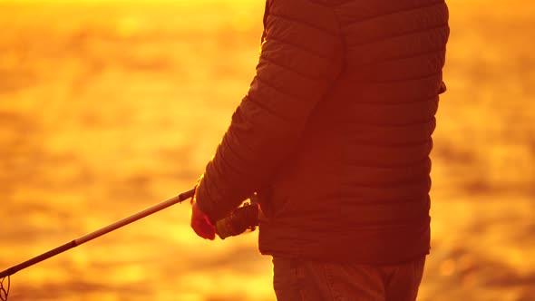 Man Hobby Fishing on Sea Tightens a Fishing Line Reel of Fish Summer