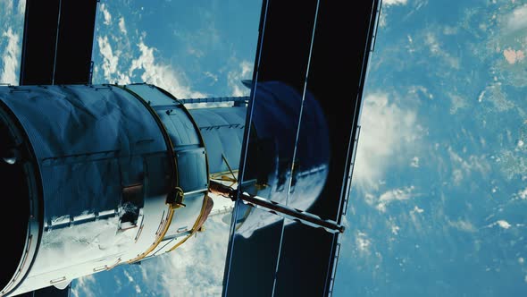 Telescope in Outer Space Near Surface of Blue Planet alt