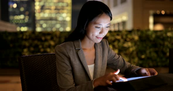 Businesswoman use of tablet computer at night 