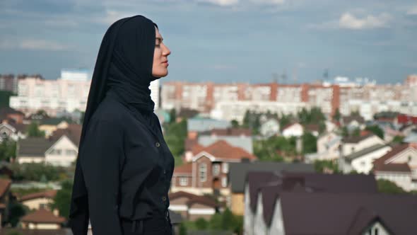 Pensive Muslim Woman in Headscarf Admiring Islamic City View From Top of Mountain Breathing Freedom