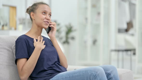 Cheerful African Woman Talking on Smartphone at Home 