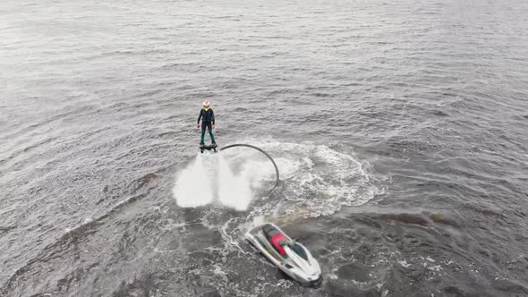 Water Sports  a Man Flying Around Over the Water with a Jet Ski Nearby  Aerial View