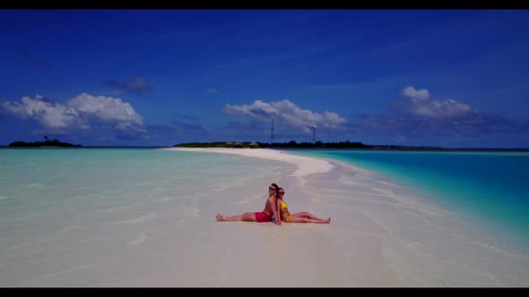 Teenage lovers posing on perfect resort beach trip by clear lagoon and white sandy background of the