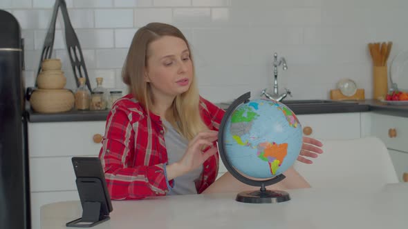 Pensive Pretty Adult Female Studying World Globe and Choosing Travel Destination