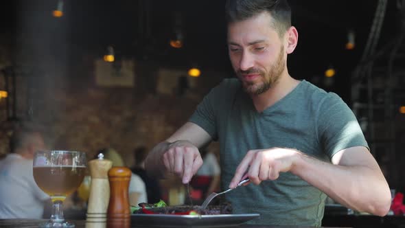 Man Eating Food At Restaurant, Cutting Meat Steak With Knife