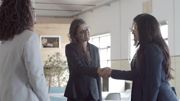 Smiling Businesswomen Greeting Each Other in Office
