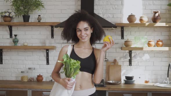 Lady with Pepper in Her Hands Promoting Healthy Eatting, Smilling and Looking at Camera