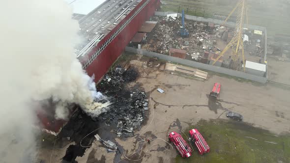 Aerial View of Firefighters Extinguishing Fire in Industrial Area