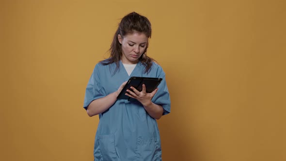 Portrait of Doctor Holding Tablet Computer and Typing Medical Data Showing Green Screen Mockup