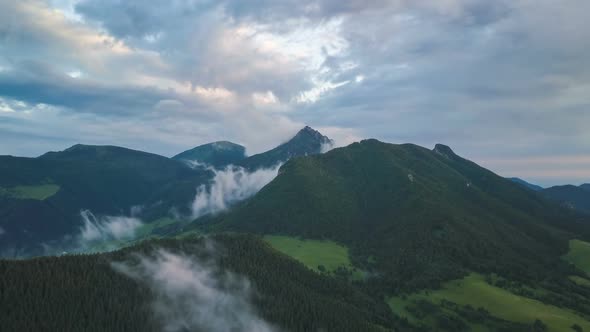 Aerial view of Green forest landscape with fast moving clods over mountains Time lapse