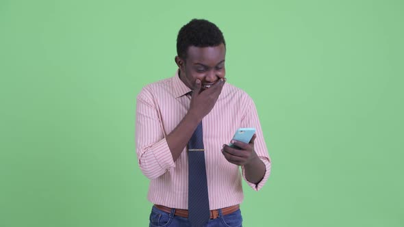 Happy Young African Businessman Using Phone and Looking Surprised