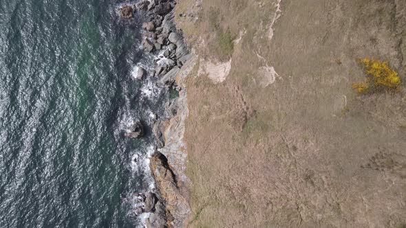 Waves Splashing On Rocky Coast In Howth, Dublin, Ireland With Scenic Top View Of Rugged Cliffs In Su