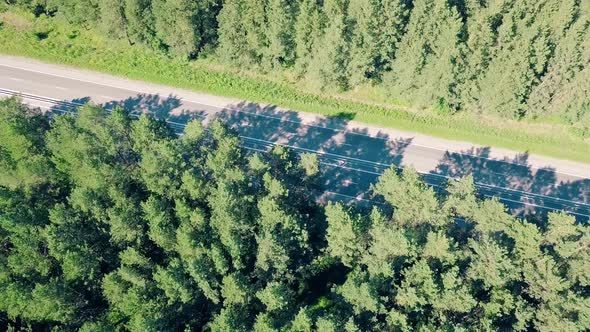 Aerial: Flying Over the Highway, Which Passes Cars and Trucks in the Forest. Direction To the Auto