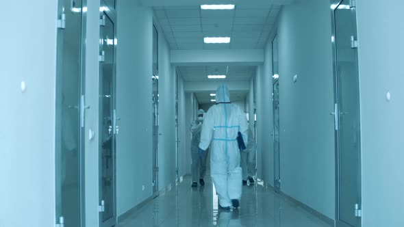 Doctors in Hazmats Move Patient on Stretcher To a Hospital Room.