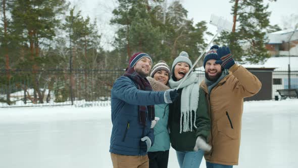 Joyful Friends Taking Selfie in Skating Rink Using Smartphone Camera Posing Having Fun