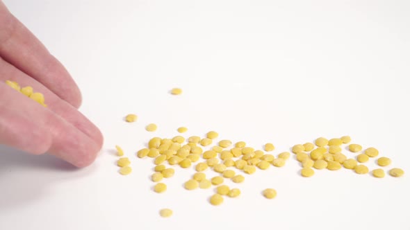 Yellow peeled lentils closeup hand sprinkles 