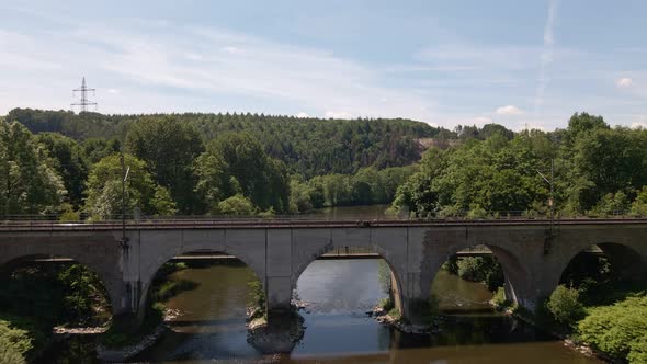 An old train trestle bridge leading over the Sieg river in west Germany on a sunny day. Wide angle a