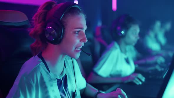 Female Gamers in Headphones Plays a Video Game Cyber Sportsmans at the Game Communication Between