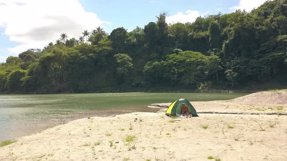 Couple of Lovers in Tent on the Sand Lake Beach Among Tropical Forest.