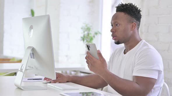 Focused Casual African Man Using Smartphone in Modern Office